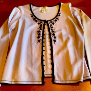 Elegant top in pale periwinkle with back trim. Detail around the neck and front.